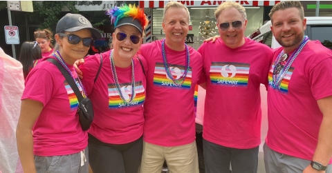 In this image, some people dressed in pink clothes are smiling while taking their pictures.