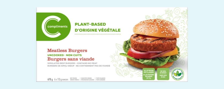 Packaging of Compliments Burgers, featuring an image of a burger with lettuce, tomato, and red onion on a sesame seed bun. Text indicates product is uncooked and non-GMO.