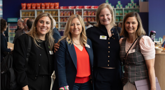 In this image, women are standing together and getting their picture taken.